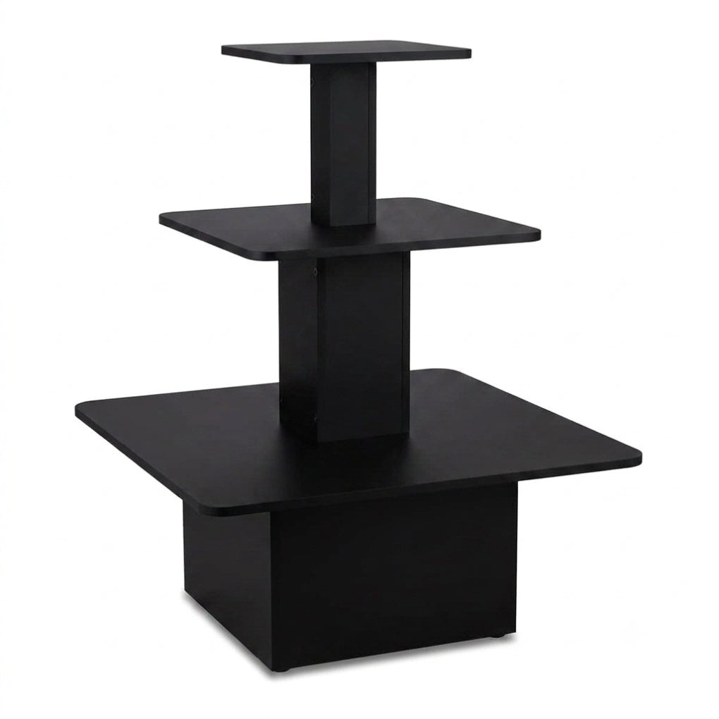 A modern three-tier black wooden display stand or riser with square platforms on a white background.