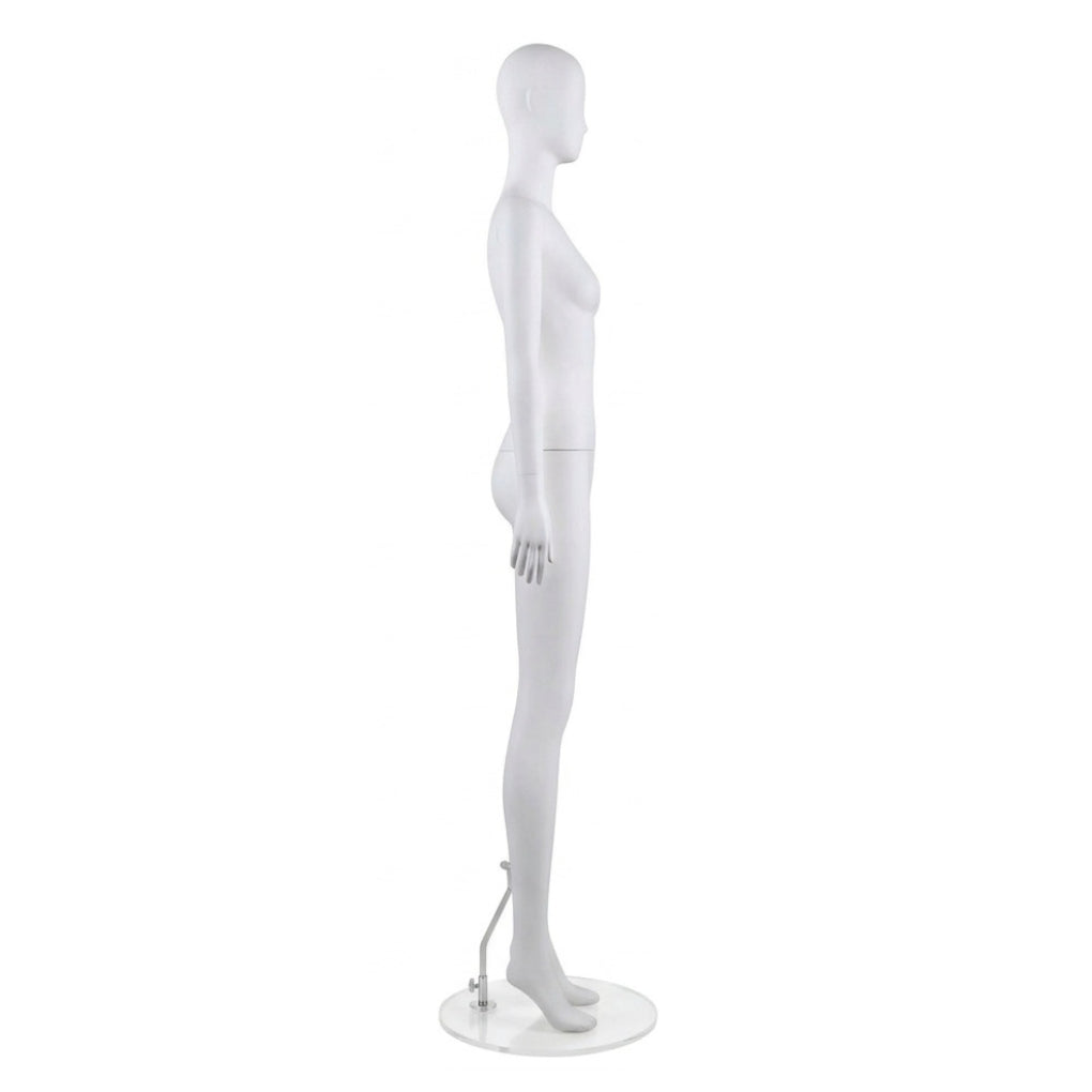 A white female mannequin figure shown in side profile, standing on a clear circular base with a small metal support arm against a plain white background.