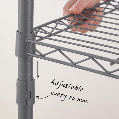Close-up of a carbon grey metal adjustable shelving unit with a hand holding a shelf rail, showing the slotted side and text reading 'Adjustable every 25 mm'