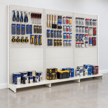 Run of three Jura White wall units against a hardware shop wall, with tools on perforated upper panels and goods on base shelves